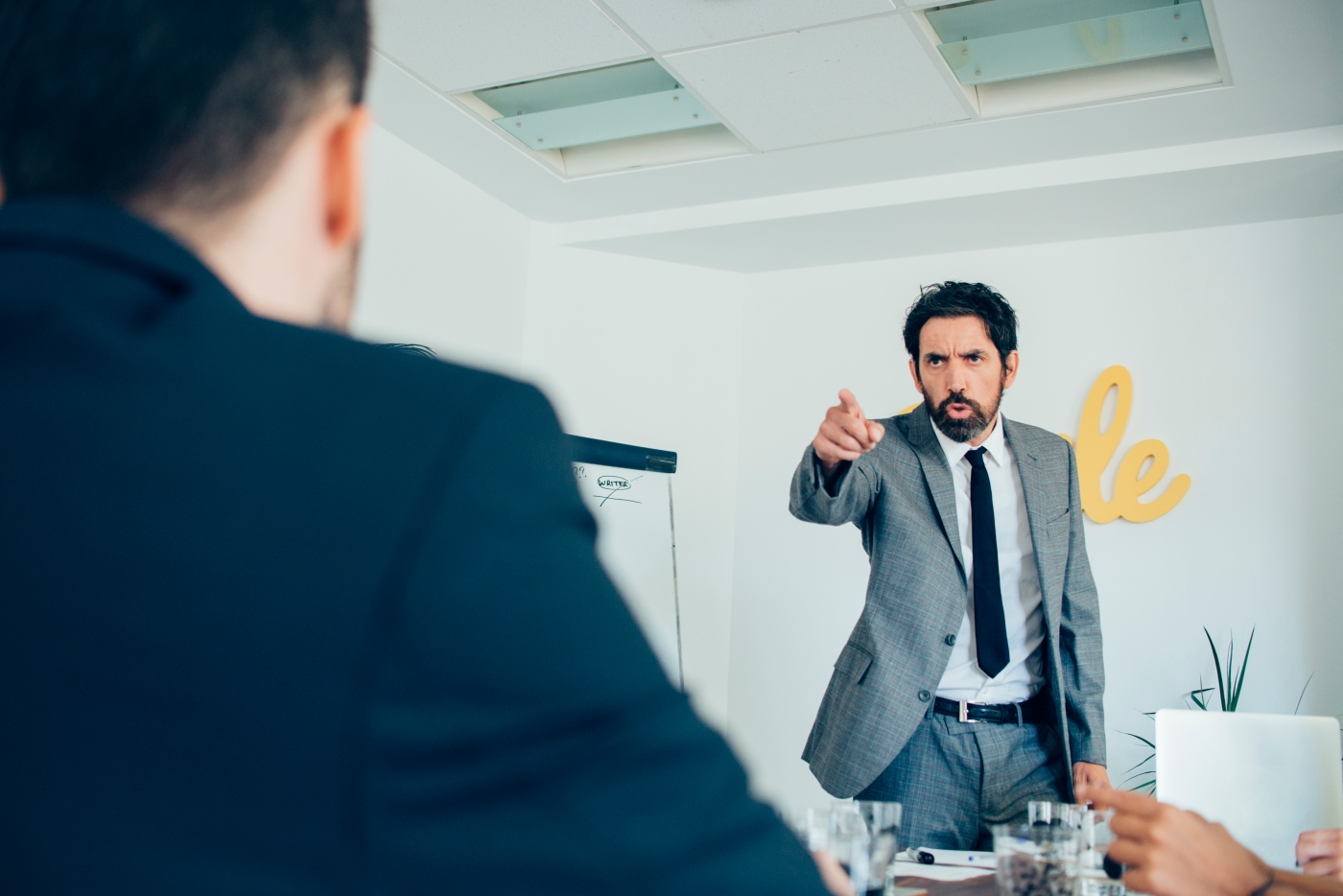angry employee pointing at another person in a meeting can be an indication of when conflict resolution in the workplace is needed